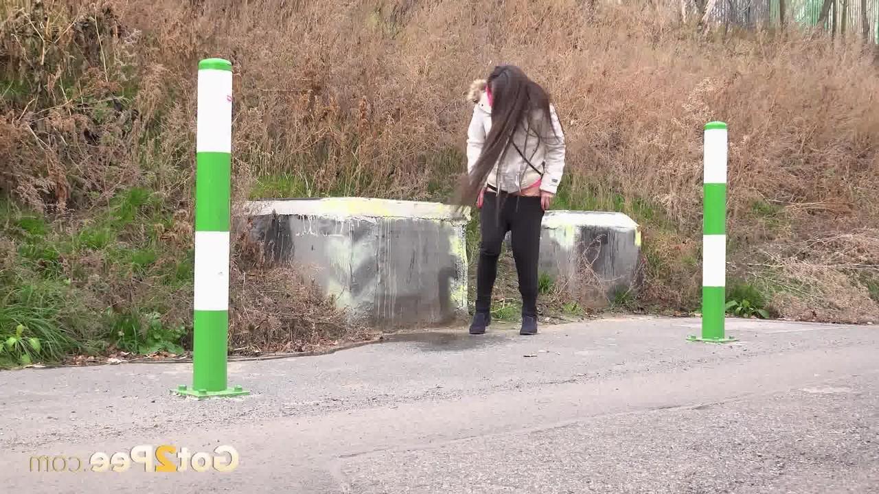 15P Caucasian girl Lara Fox squats for a badly needed pee upon a paved roadway