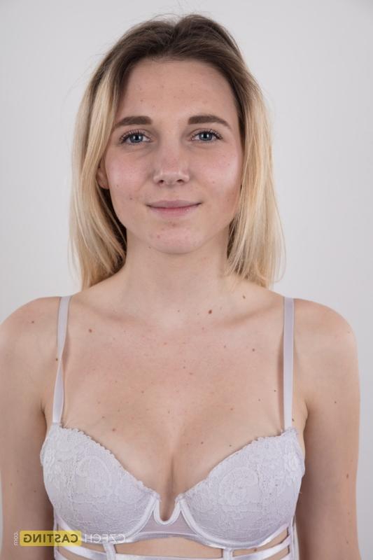 20P Une jeune blonde croise les jambes après s'être complètement nue sur un tabouret