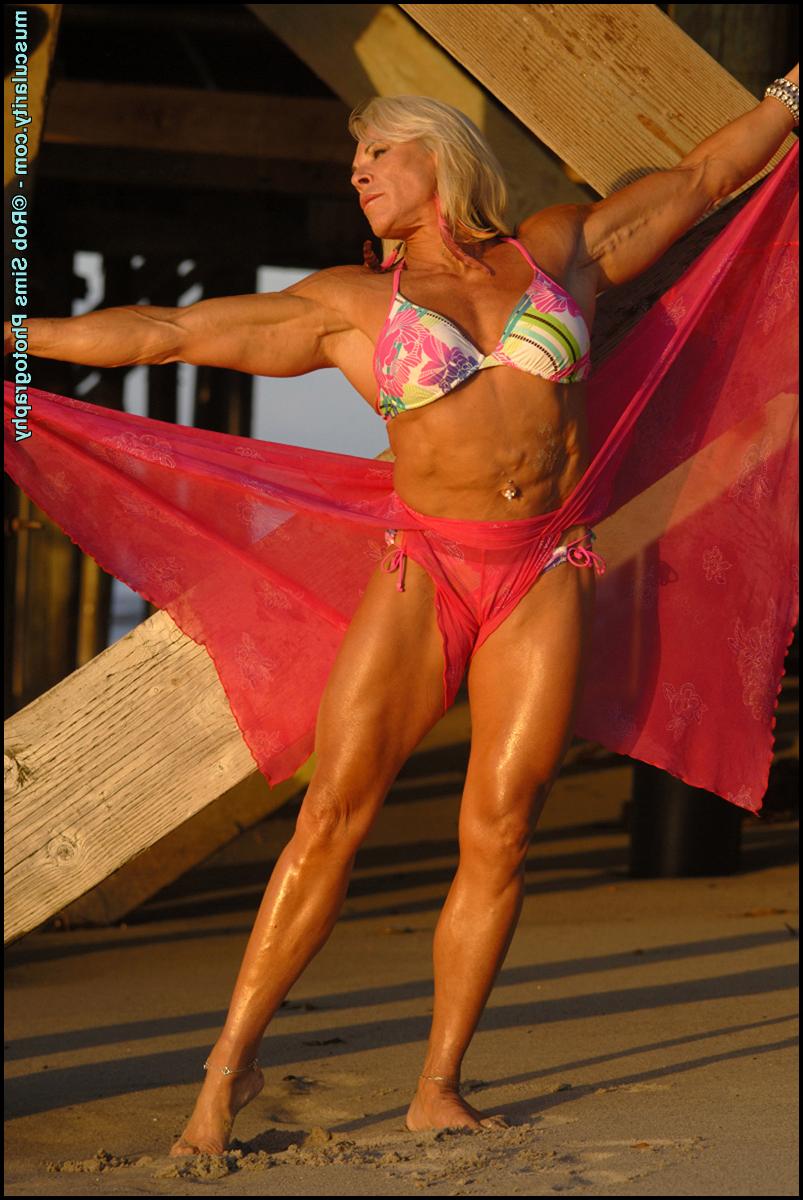 15P La culturista rubia Lauren Powers se flexiona debajo de un muelle en bikini