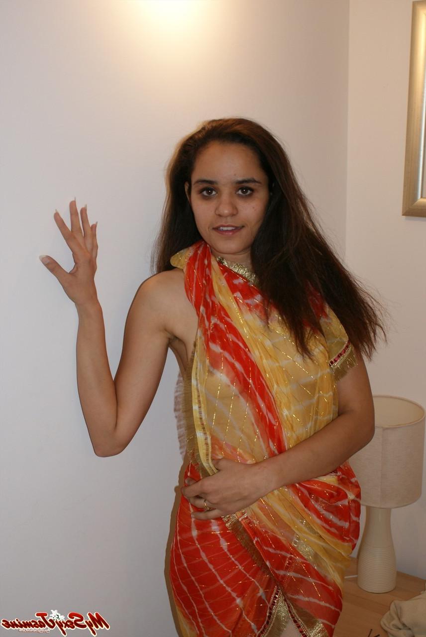 11P Une fille indienne solo libère ses seins naturels de ses vêtements sur un lit
