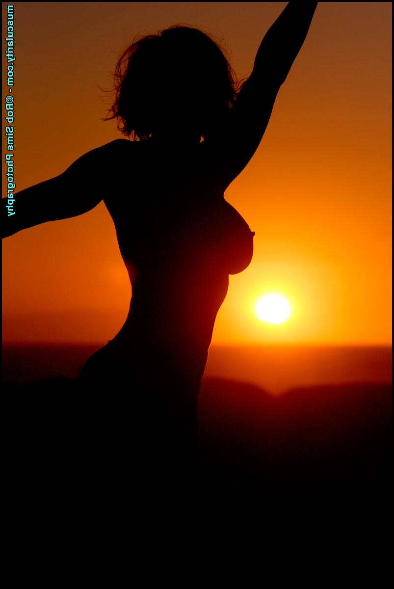 15P Bodybuilder Heather Bartosh slips off a bra while modelling on a patch of sand