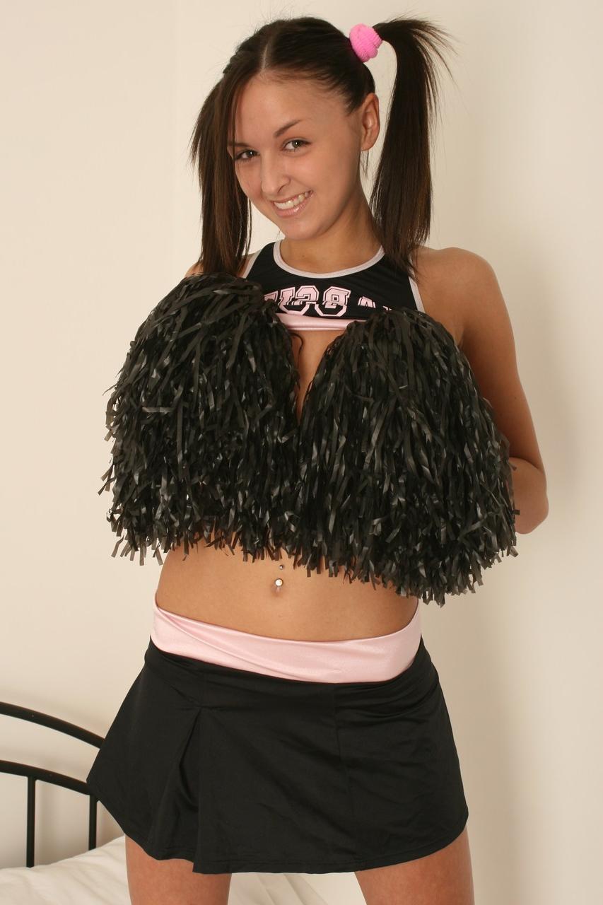 20P Zierliches Mädchen zieht ihr Cheerleader-Outfit aus, um nackt mit Zopfhaaren zu posieren