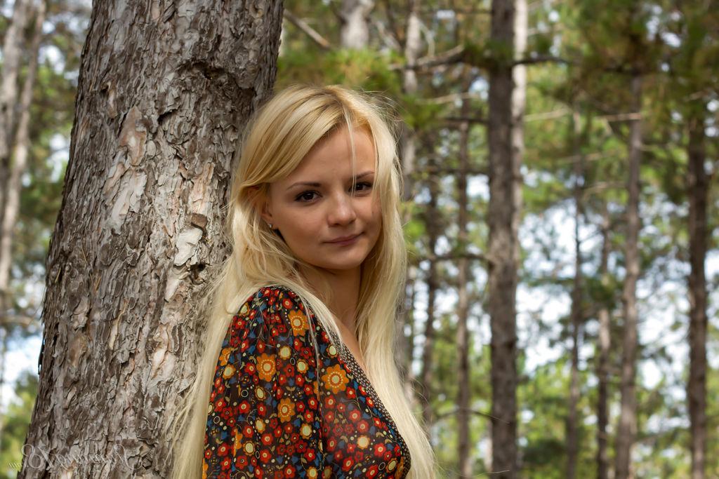 16P Die junge Blondine Sallustia K zieht sich im Wald nackt an einem Baum aus