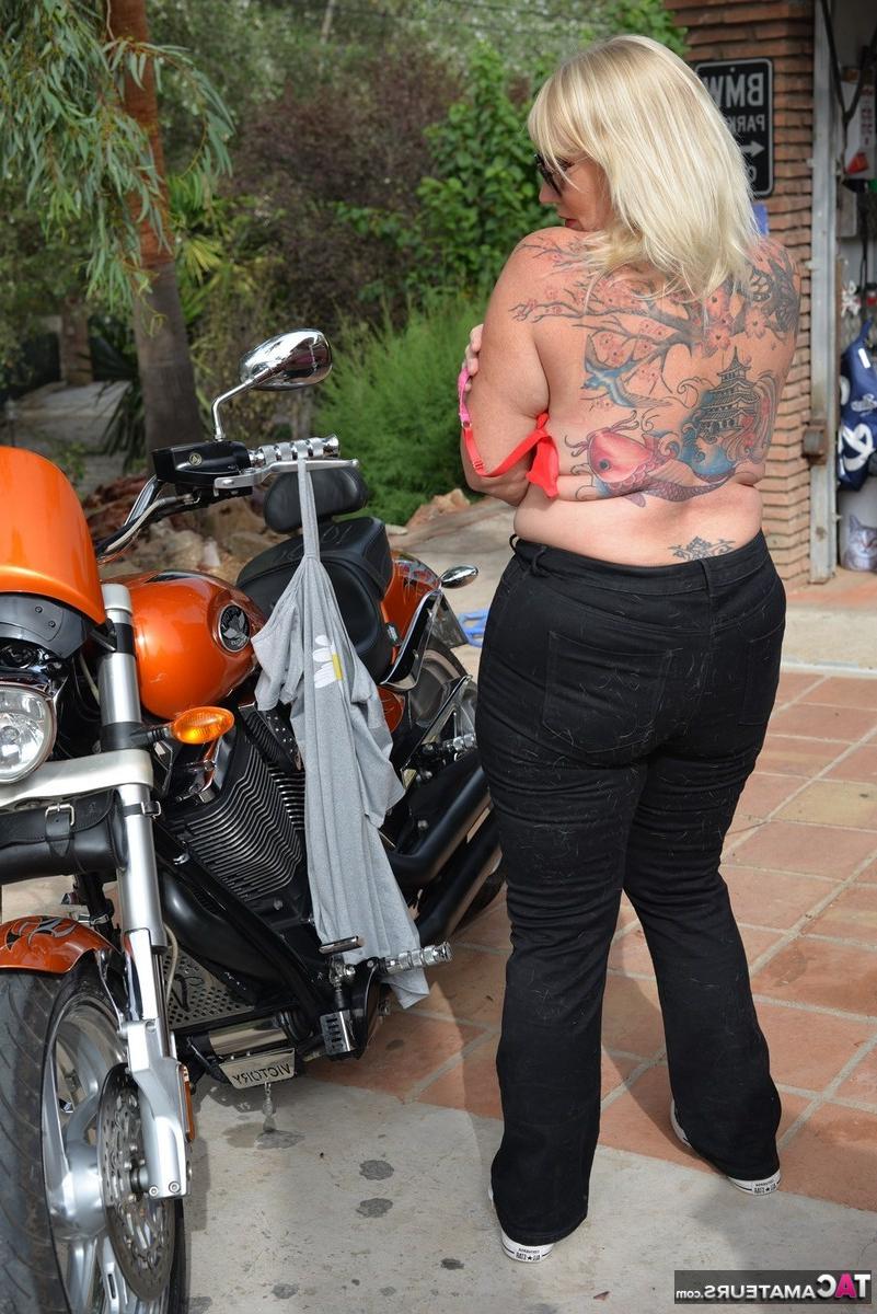 16P Melody, blonde en surpoids, se met seins nus après être descendue de sa moto.