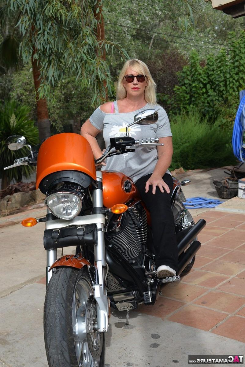 16P Melody, blonde en surpoids, se met seins nus après être descendue de sa moto.