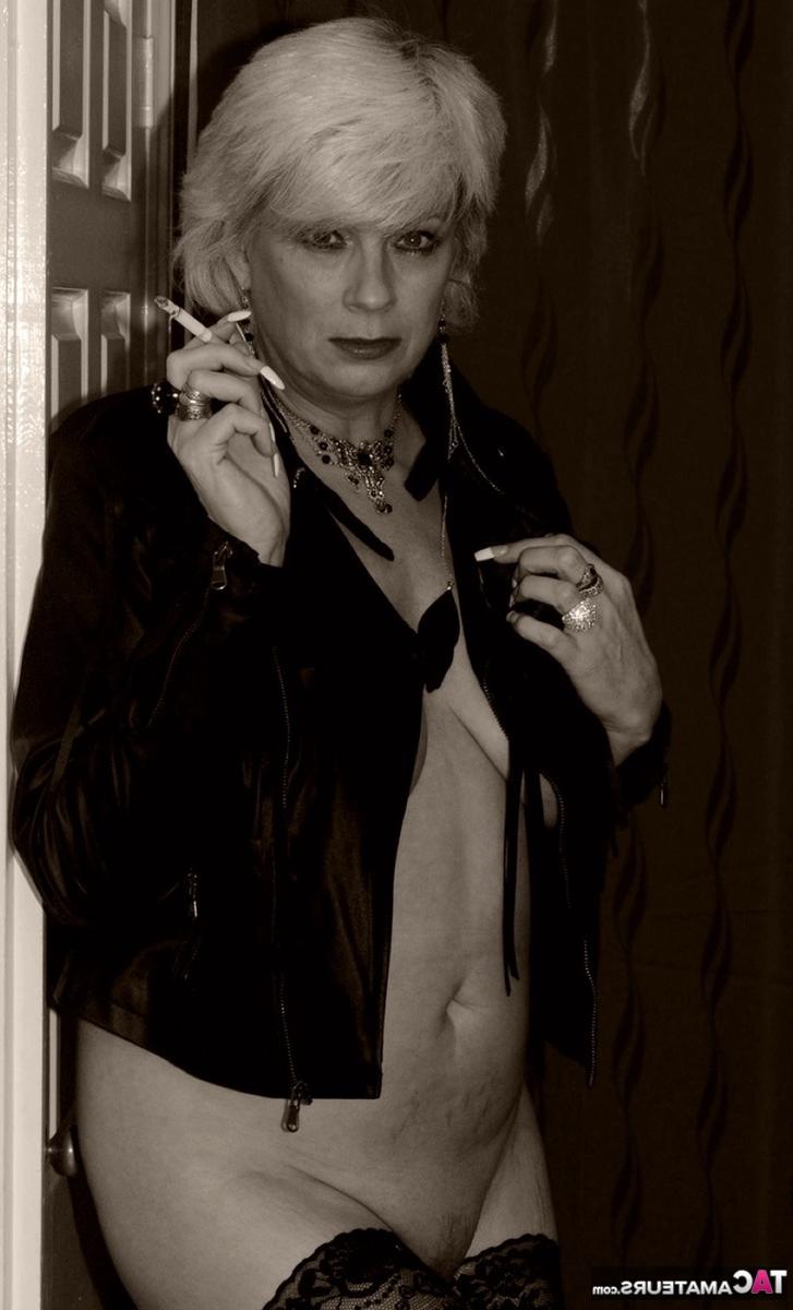 16P La blonde plus âgée Dimonty montre ses seins et sa chatte en fumant une cigarette.