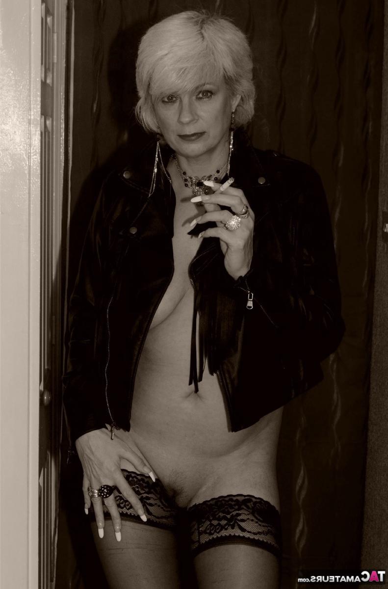 16P La blonde plus âgée Dimonty montre ses seins et sa chatte en fumant une cigarette.