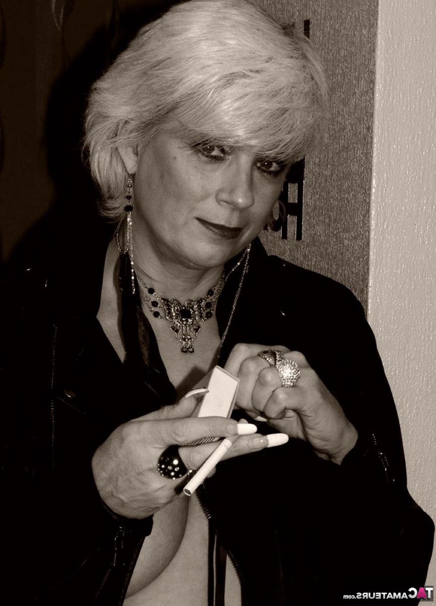 16P La blonde plus âgée Dimonty montre ses seins et sa chatte en fumant une cigarette.