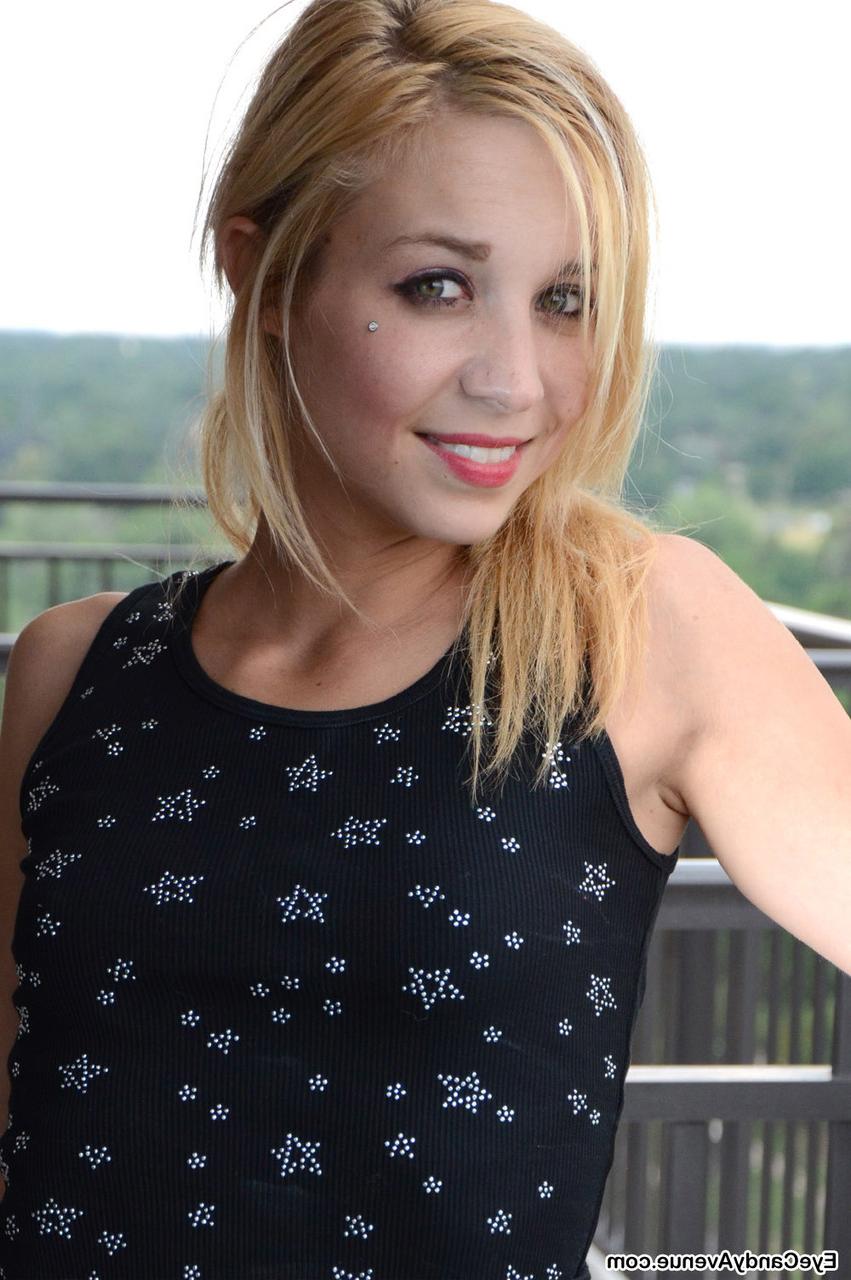 16P La douce jeune blonde Marissa se met seins nus sur un balcon en culotte et chaussettes roses.