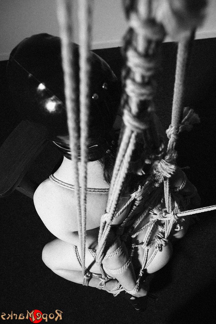 15P Caucasian female is restrained with ropes in a black latex hood