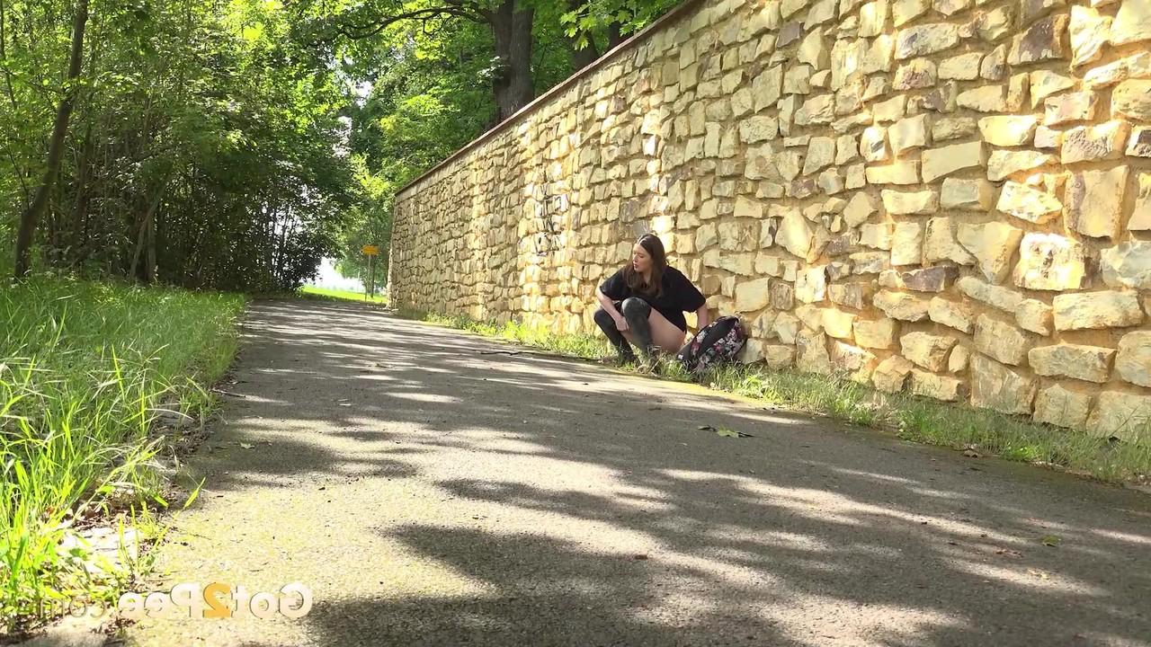 14P Das hübsche Mädchen Aleya zieht ihre Hose herunter, um auf eine gepflasterte Straße zu pinkeln