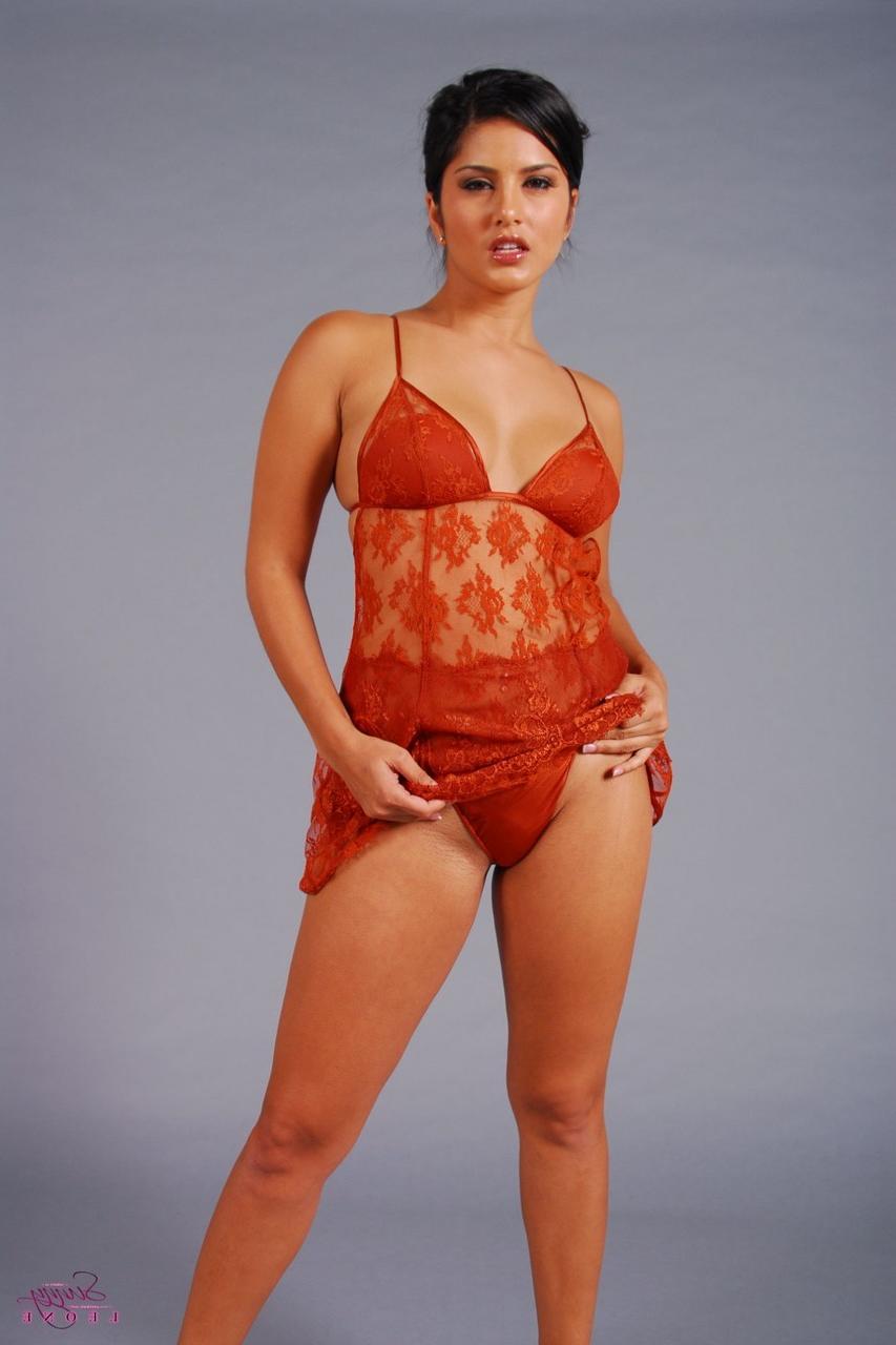 20P La MILF brune Sunny Leone dévoile ses petits seins dans un strip-tease en lingerie sexy.