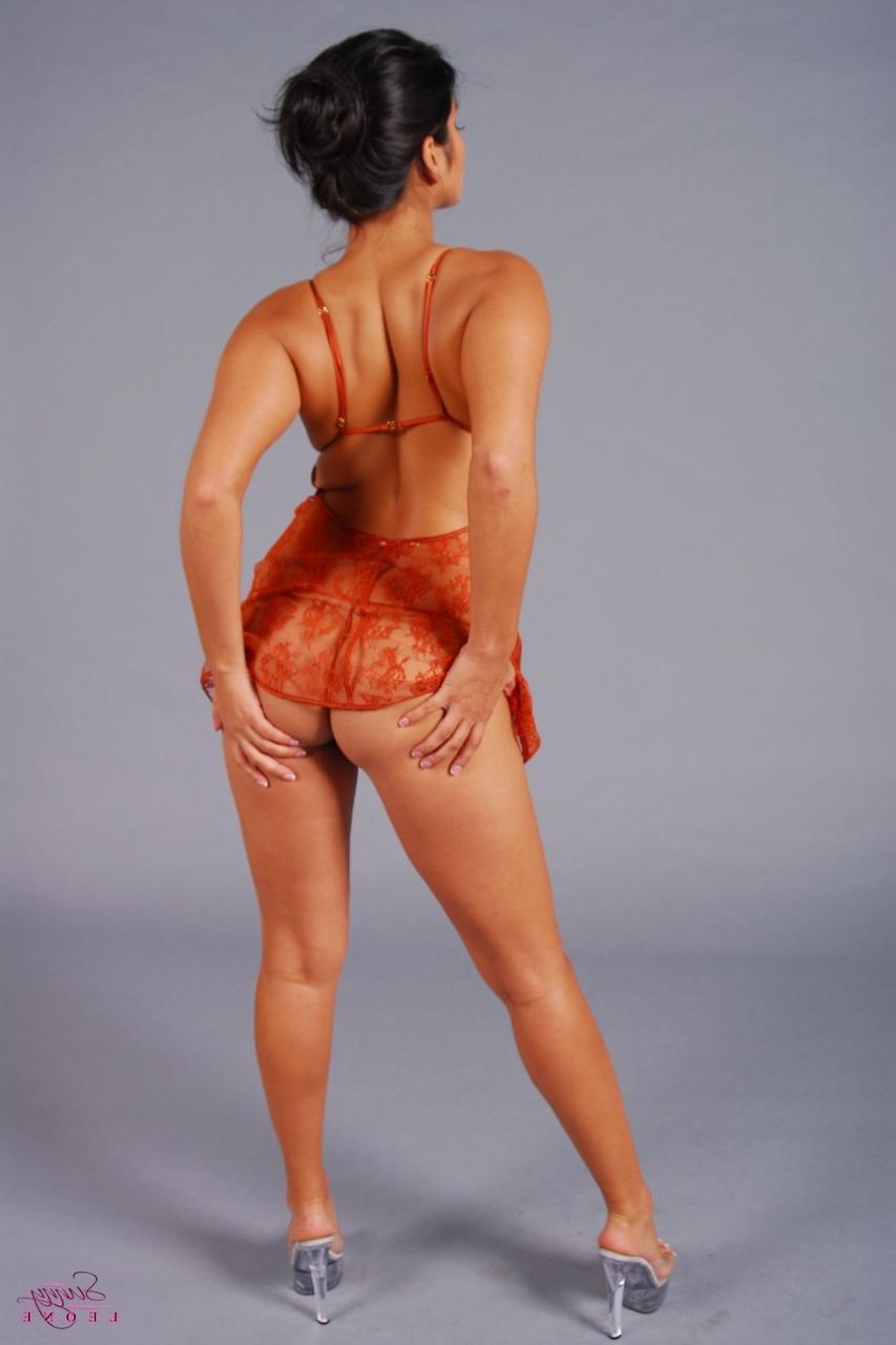 20P La MILF brune Sunny Leone dévoile ses petits seins dans un strip-tease en lingerie sexy.
