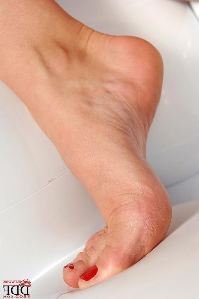 16P Cherry Jul, modèle solo blonde, enlève ses bas nylons noirs et ses talons aiguilles.