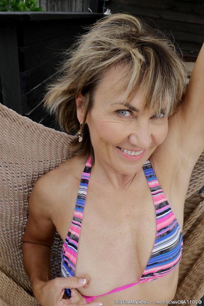 15P La madura Lillian Tesh se mete los dedos en el coño en una hamaca después de quitarse el bikini