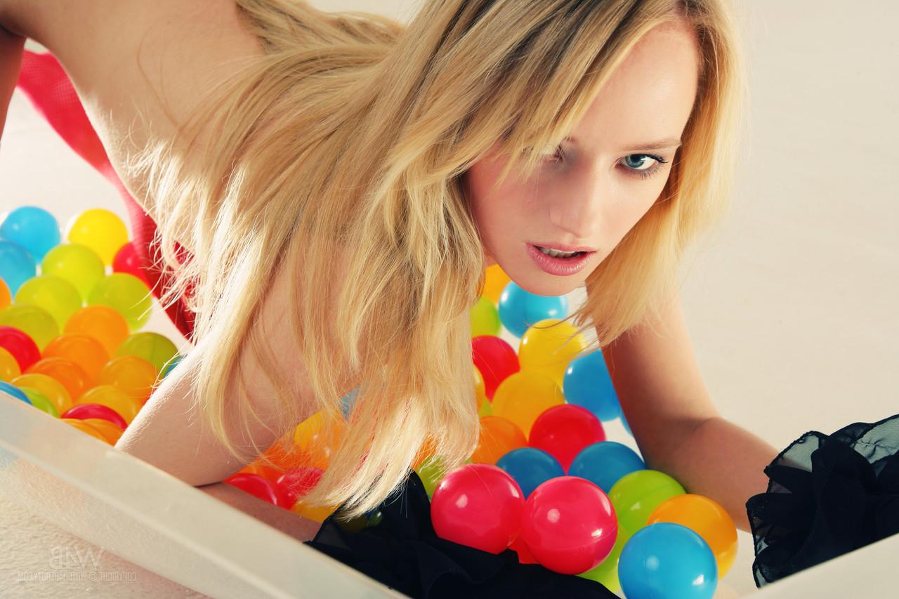 20P La joven rubia mia acaricia sus pequeñas tetas naturales y posa con medias rojas