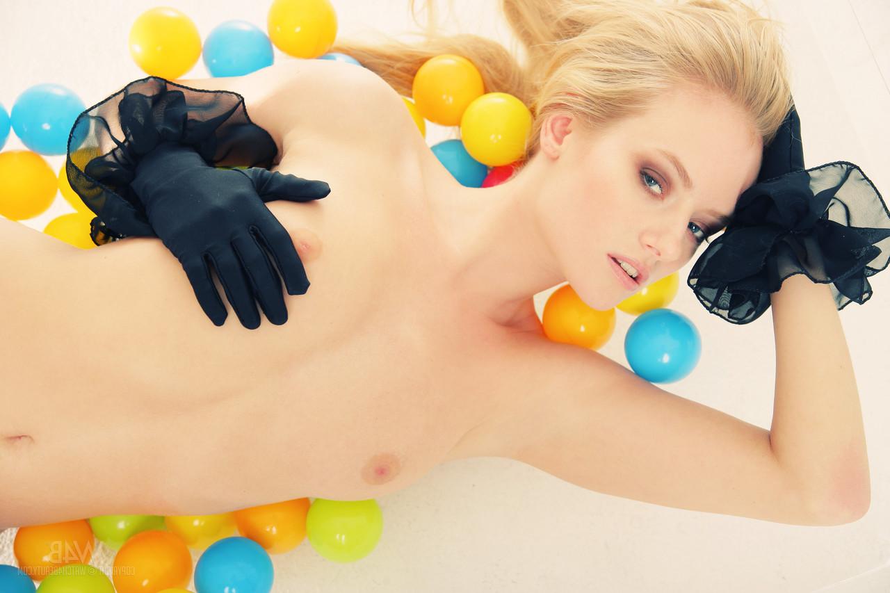 20P La joven rubia mia acaricia sus pequeñas tetas naturales y posa con medias rojas