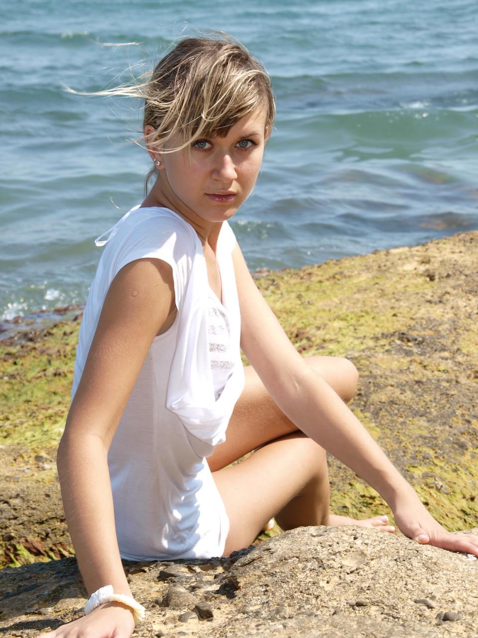 18P Die schlanke blonde Teenagerin Viki D fängt die Sonne auf ihrem nackten Körper unten am Meer ein