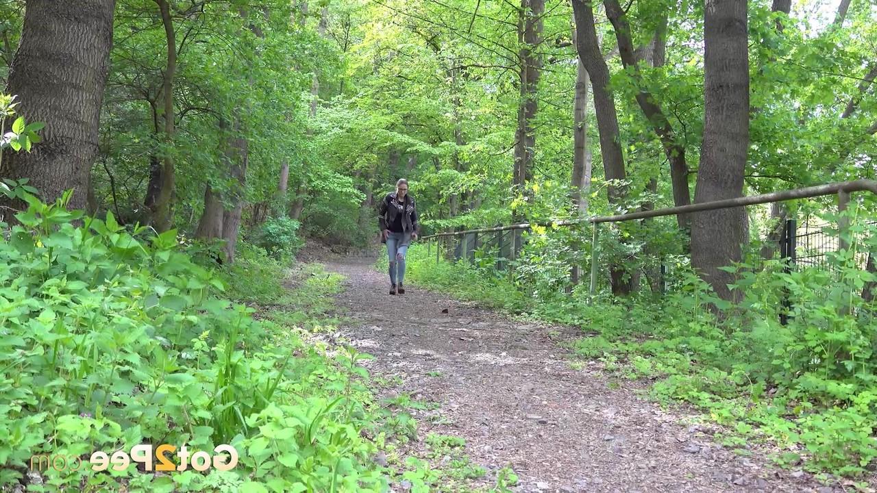 15P La gentille fille Barbe pisse sur un chemin à travers les bois avec une veste et des lunettes