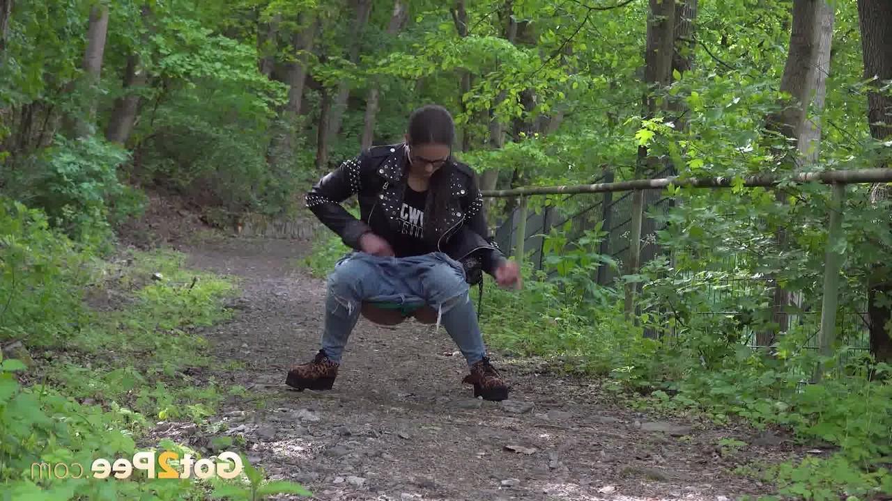 15P La gentille fille Barbe pisse sur un chemin à travers les bois avec une veste et des lunettes