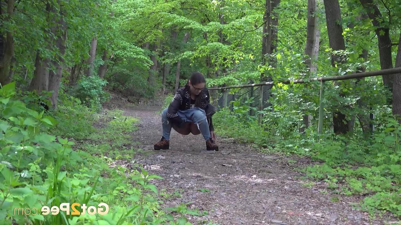 15P La gentille fille Barbe pisse sur un chemin à travers les bois avec une veste et des lunettes
