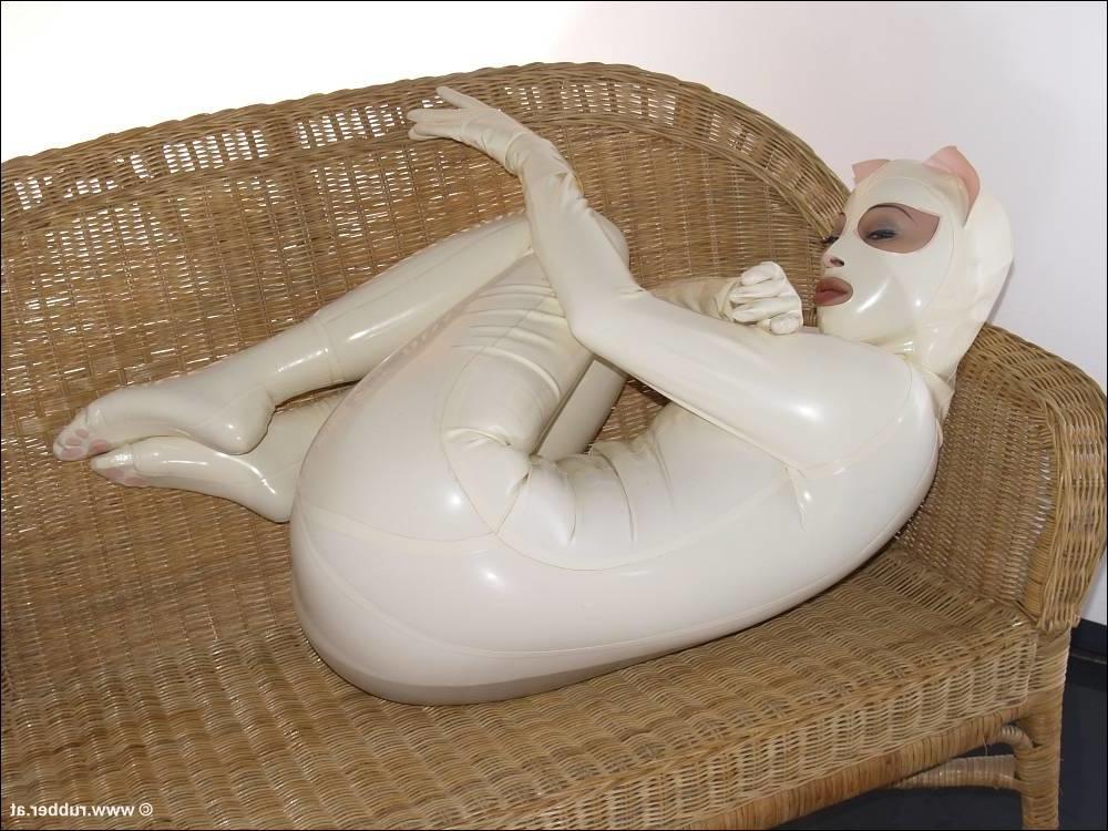 16P Bald female models rubber attire during a solo engagement