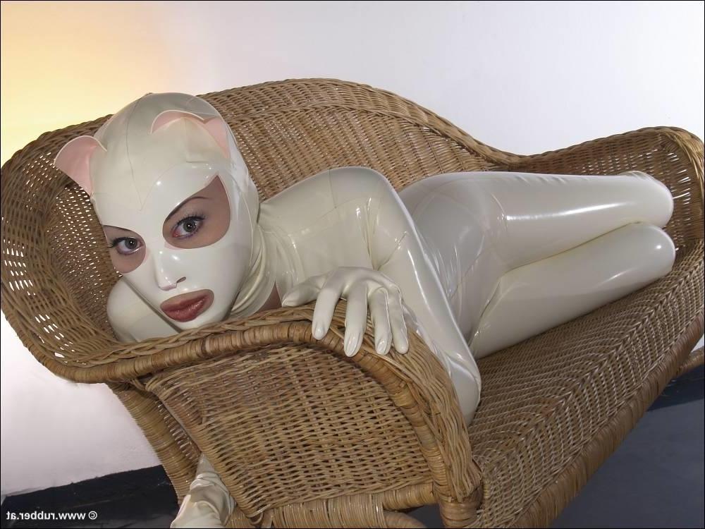 16P Bald female models rubber attire during a solo engagement
