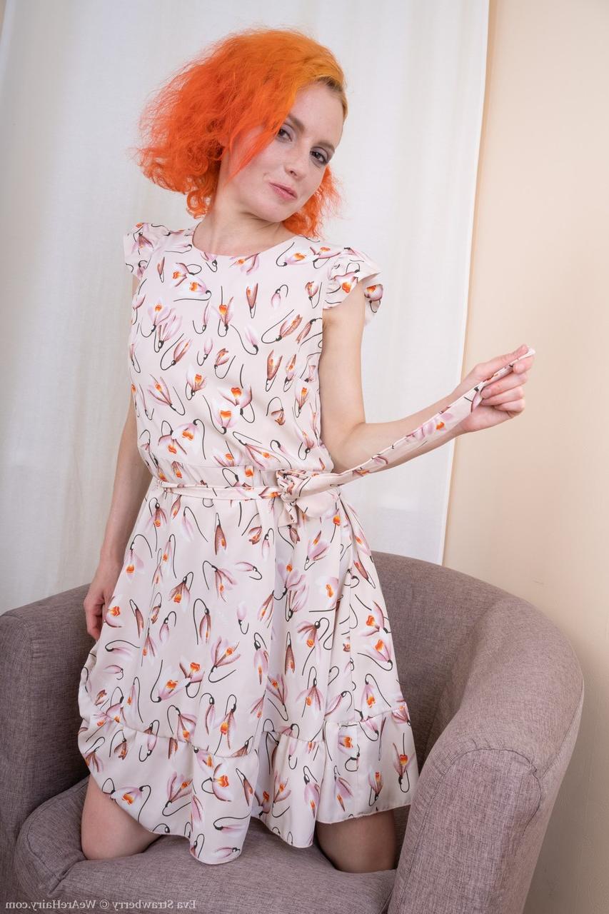 20P L'Américaine rousse sexy Eva Strawberry dévoile ses petits seins et sa chatte poilue.