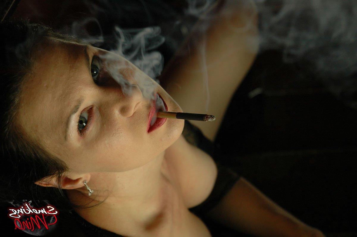 15P Brunette chick Mina smokes while modeling fetish attire in boots