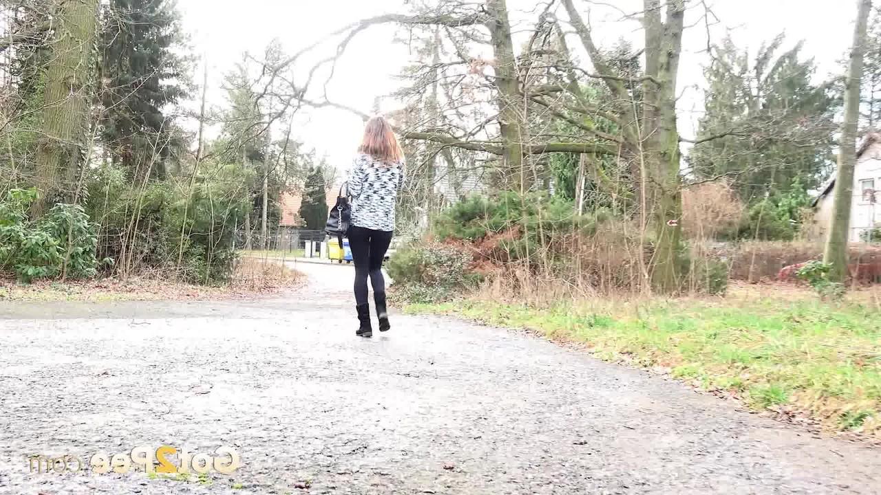 15P La gentille fille Cynthia Vellons baisse ses leggings noirs pour faire pipi contre un arbre.