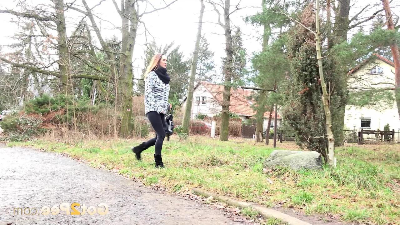 15P La gentille fille Cynthia Vellons baisse ses leggings noirs pour faire pipi contre un arbre.