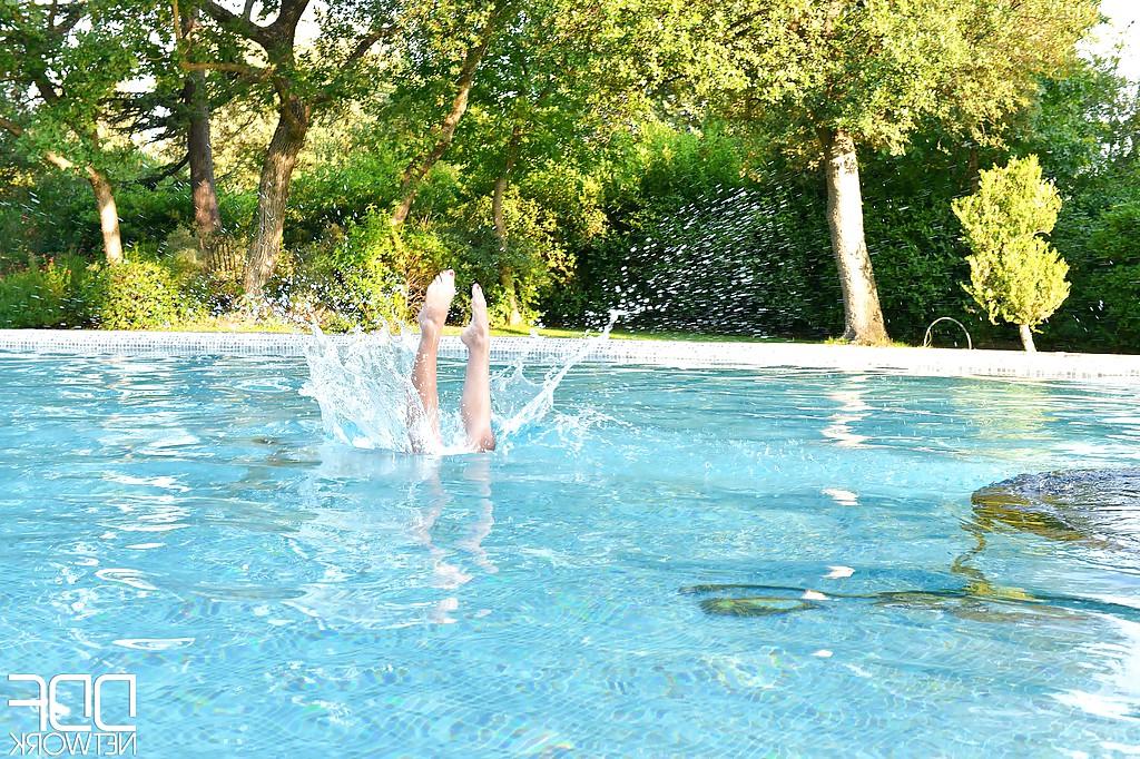 16P La nena solitaria Loulou Petite mostrando sus piernas sexys y sus pies descalzos al aire libre en la piscina