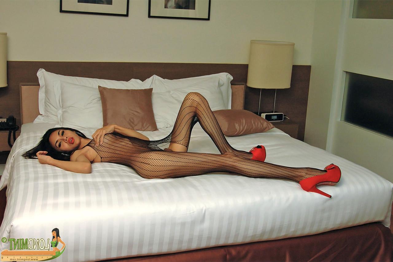 20P Ladyboy in sexy Bodystocking und High Heels packt ihren großen Schwanz und streichelt ihn
