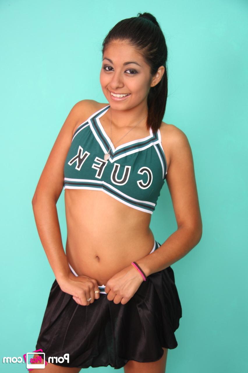 20P Petite cheerleader Ruby Rayes exposes her titties and round ass and poses