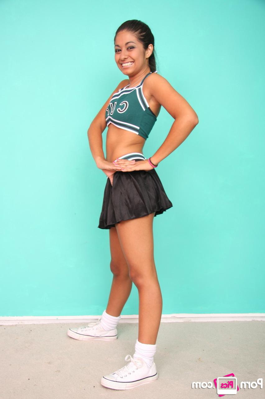 20P Petite cheerleader Ruby Rayes exposes her titties and round ass and poses