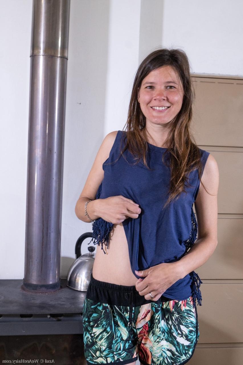 20P Azul, une amatrice en chaleur, montre ses petits seins et sa chatte poilue sur un poêle à bois.