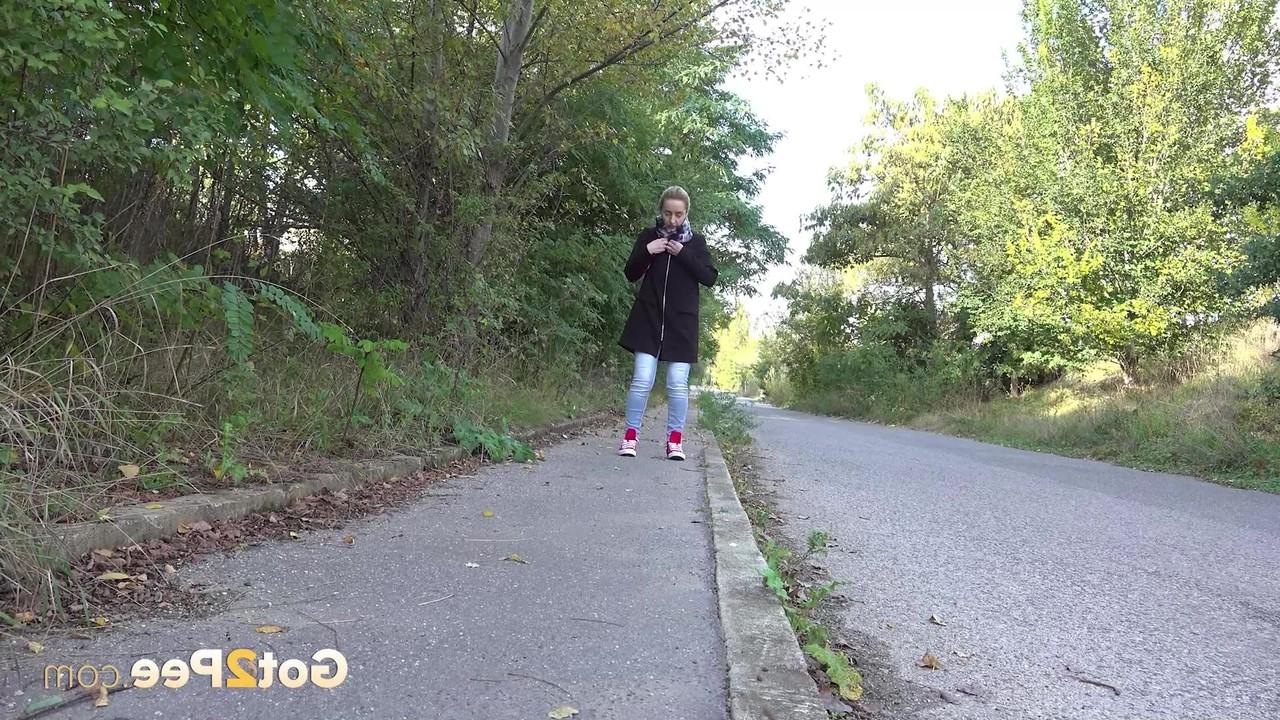 15P Pretty blonde Di Devi pulls down her jeans to pee on a public sidewalk