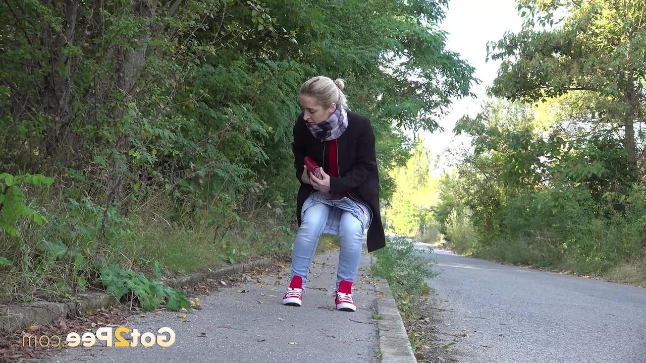 15P Pretty blonde Di Devi pulls down her jeans to pee on a public sidewalk