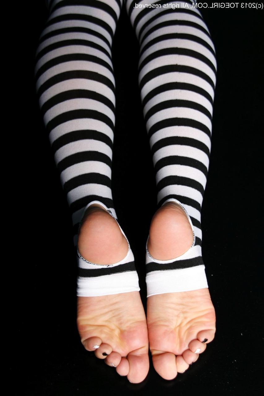 16P Chica caucásica muestra sus pies mientras usa tacones y medias hasta los muslos sin dedos