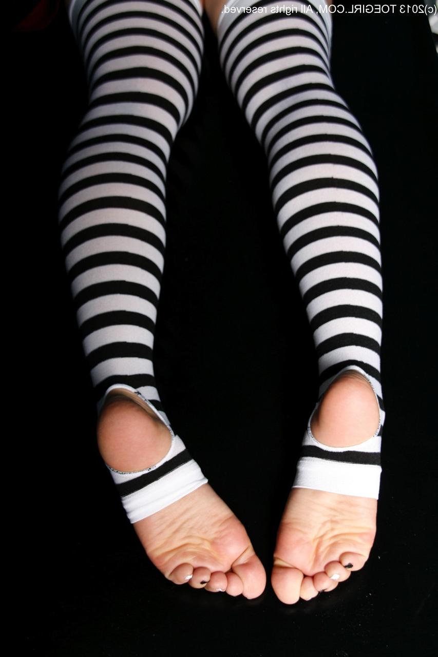 16P Chica caucásica muestra sus pies mientras usa tacones y medias hasta los muslos sin dedos