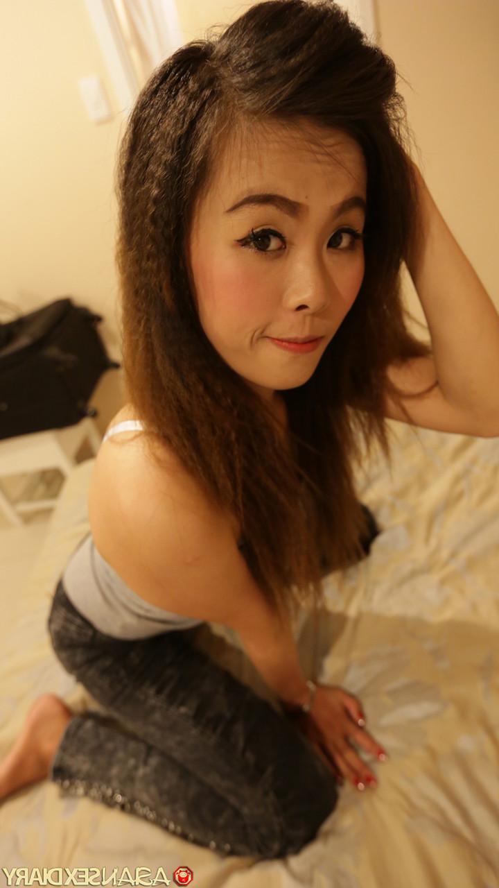 20P Die lüsterne asiatische Teenagerin Pety enthüllt ihren tätowierten Körper und lässt sich ihre haarige Fotze entbeinen
