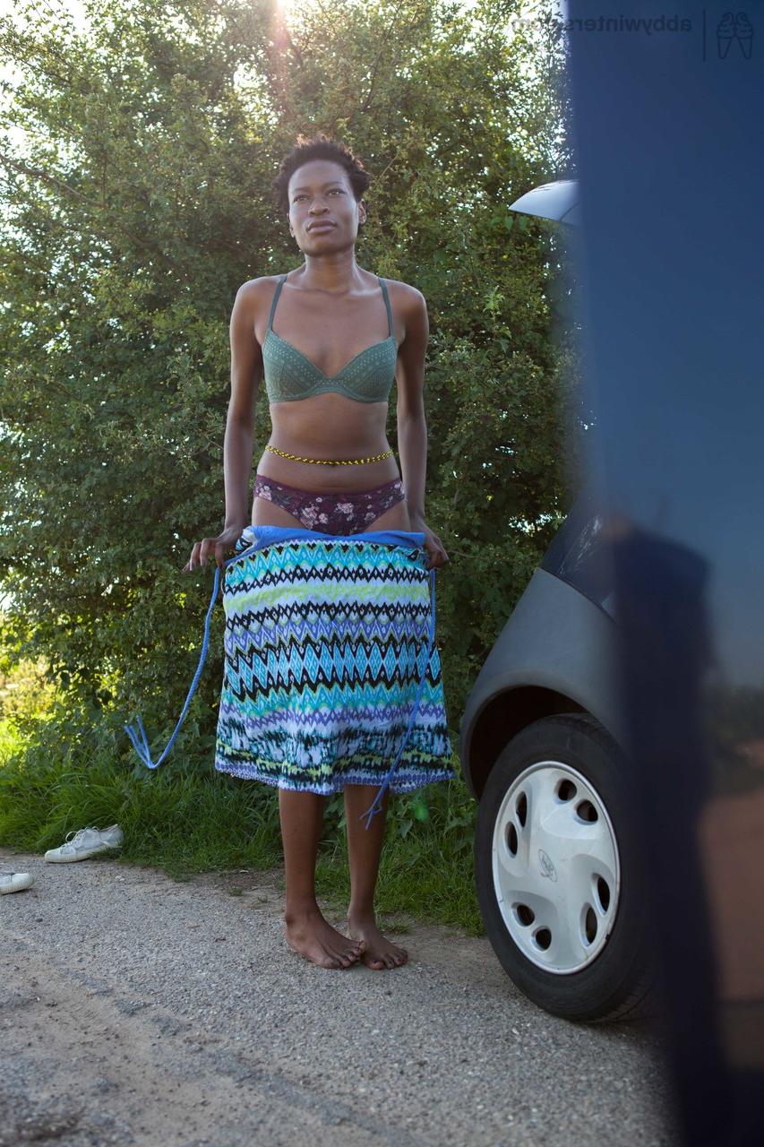 16P Naked black female with long legs gets dressed by the side of the rode
