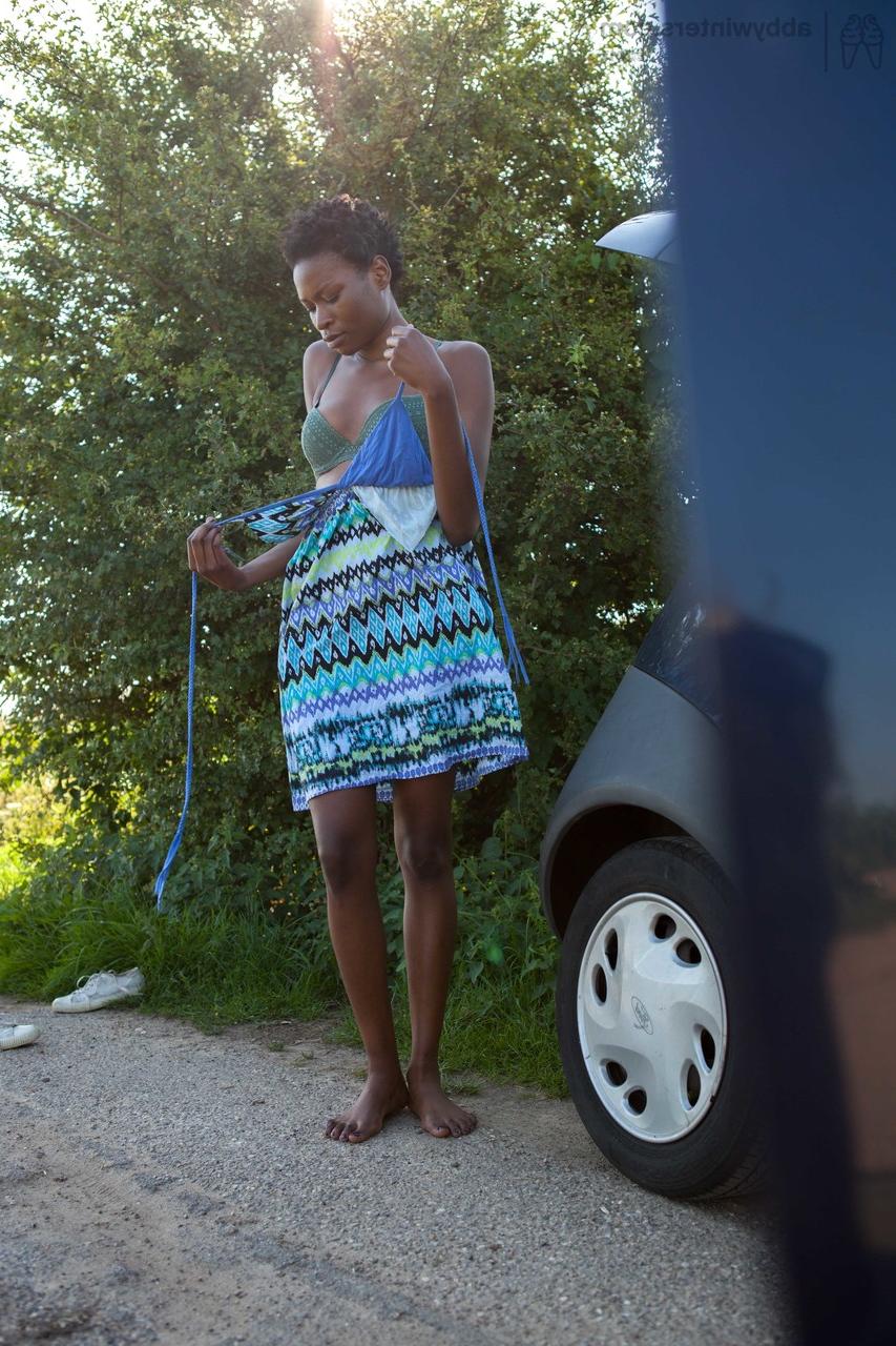 16P Naked black female with long legs gets dressed by the side of the rode