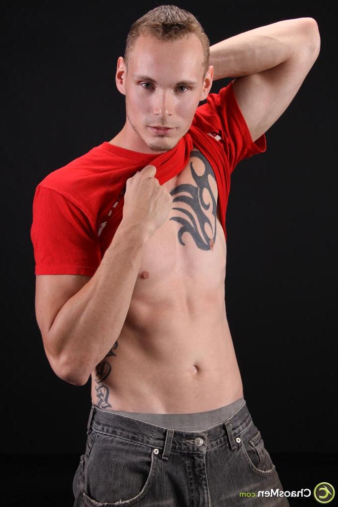 20P El modelo gay rubio Kirk muestra su cuerpo tatuado y se masajea la polla en el sofá