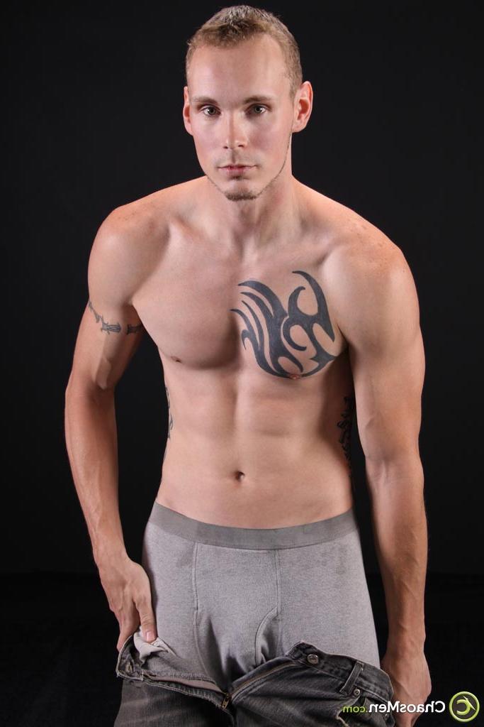 20P El modelo gay rubio Kirk muestra su cuerpo tatuado y se masajea la polla en el sofá