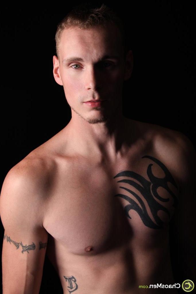 20P El modelo gay rubio Kirk muestra su cuerpo tatuado y se masajea la polla en el sofá