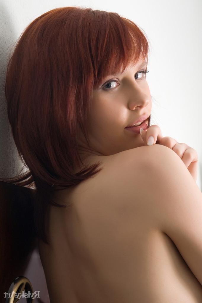 16P Pale redhead Anelie casts sultry looks while getting naked on a window sill