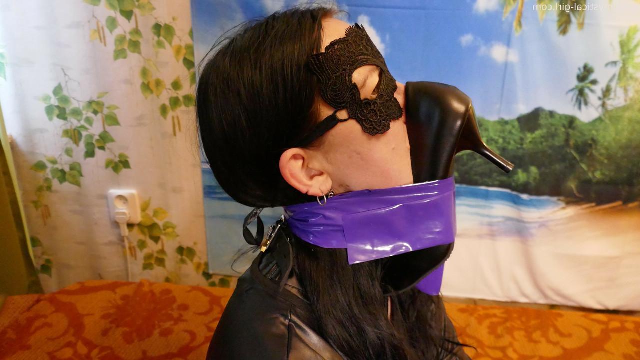 16P Caucasian woman sports a mask while modelling leather clothing and footwear