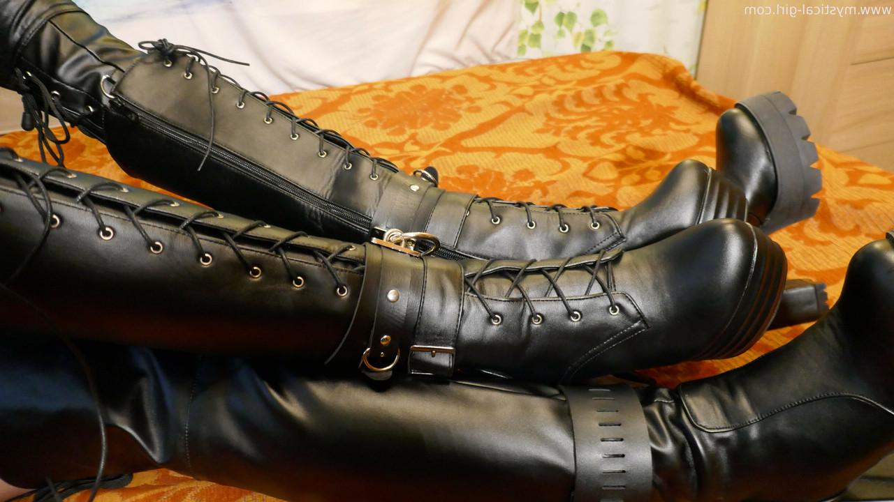 16P Caucasian woman sports a mask while modelling leather clothing and footwear