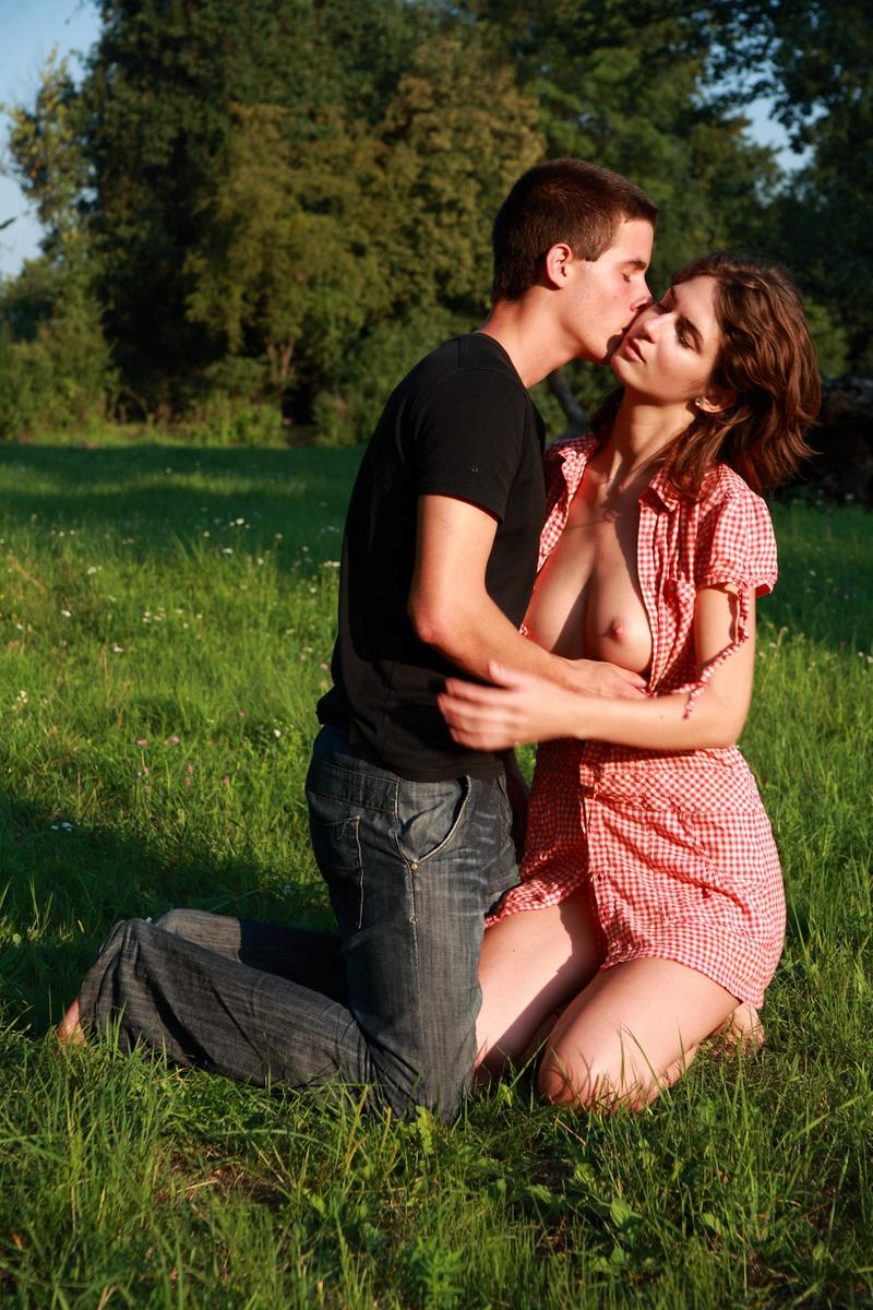 20P Young couple have sexual intercourse in a grassy field near a gnarly tree
